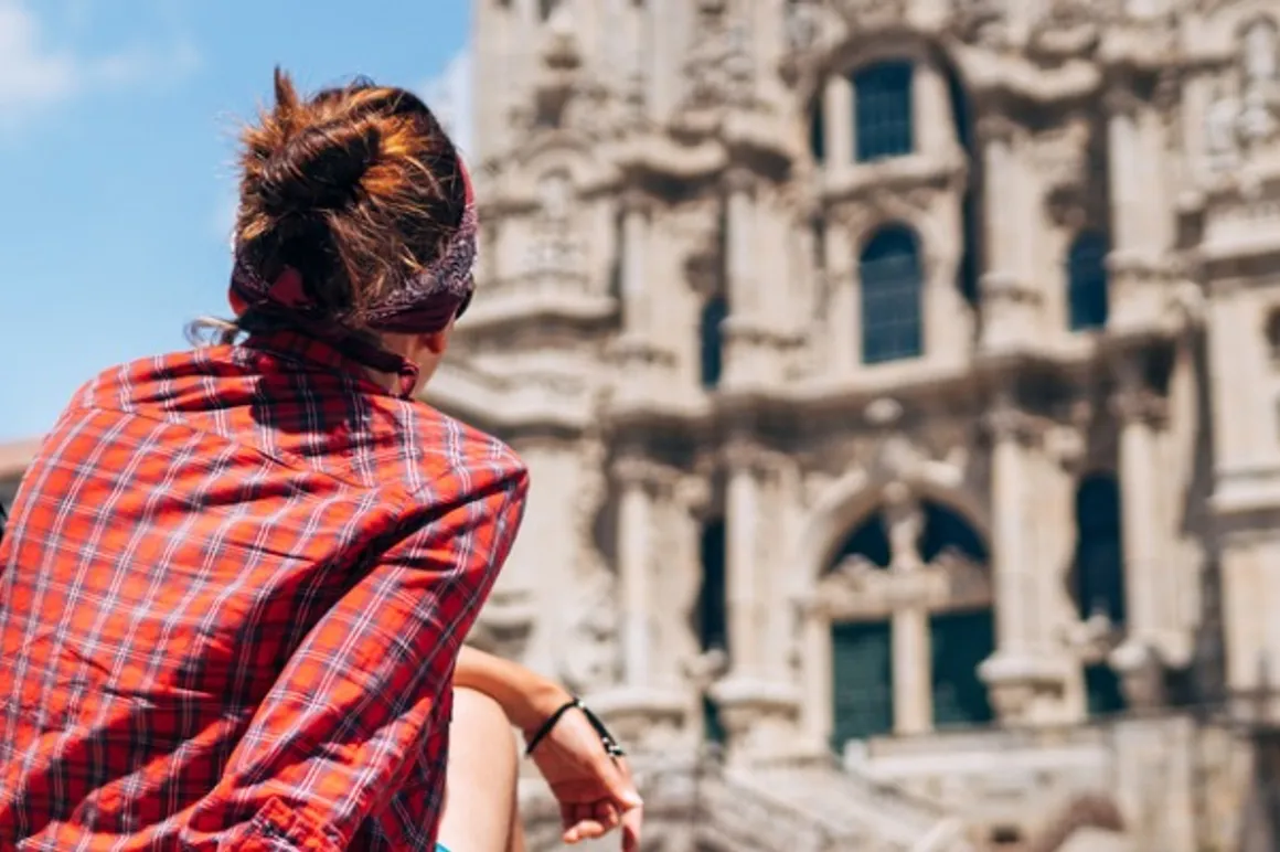 woman backpacker piligrim siting on the obradeiro square in santiago picture id1165263782 150x150